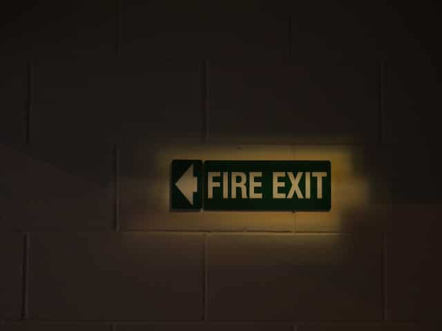 Leuchtendes Notausgangsschild mit „FIRE EXIT“.