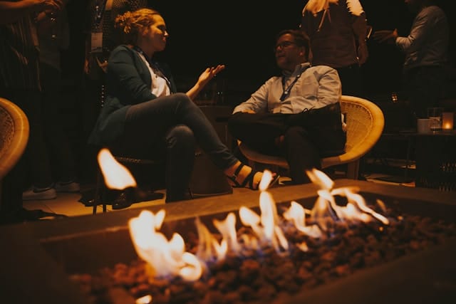 Zwei Personen im Gespräch am Lagerfeuer.